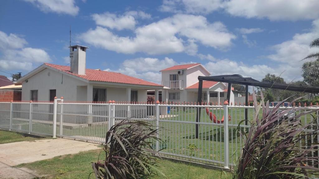 a white fence in front of a house at Casas El Timón A in Chuí