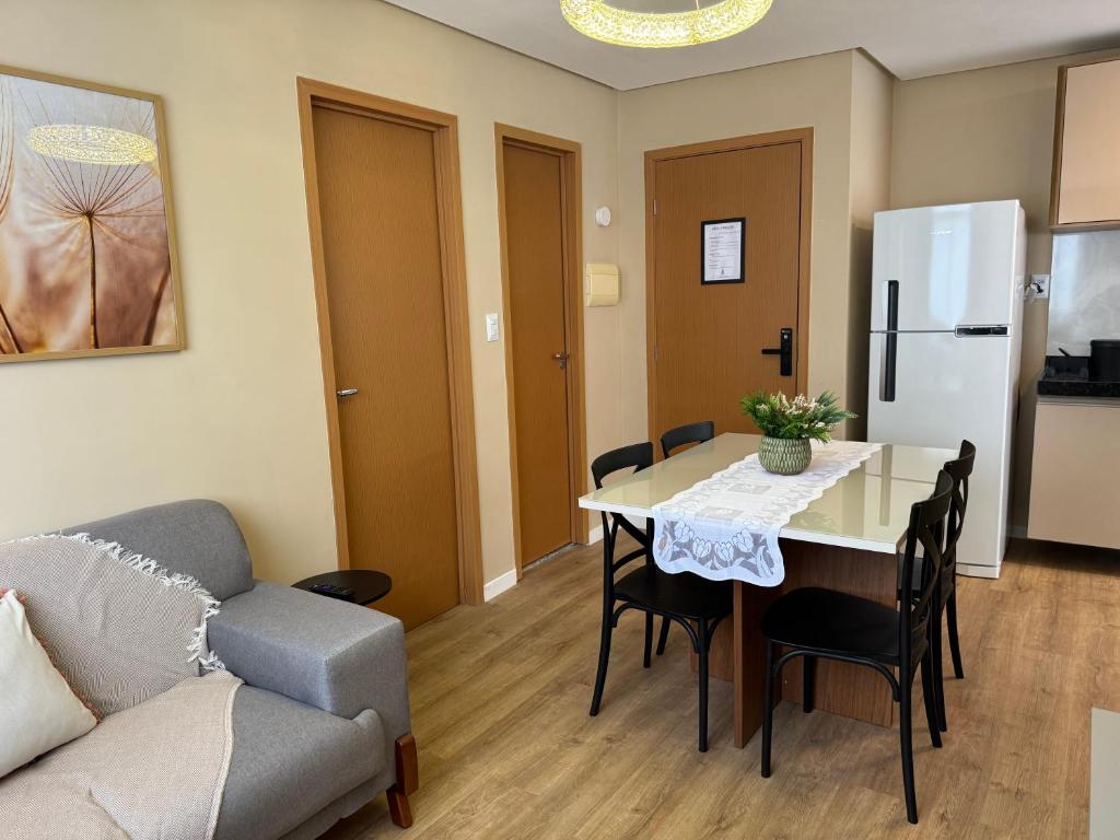 eine Küche und ein Wohnzimmer mit einem Tisch und einer Couch in der Unterkunft Novo, decorado e perto de tudo in Ananindeua