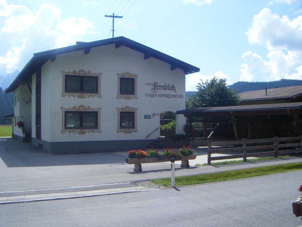un petit bâtiment blanc avec des fleurs devant lui dans l'établissement Fernblick, à Leutasch