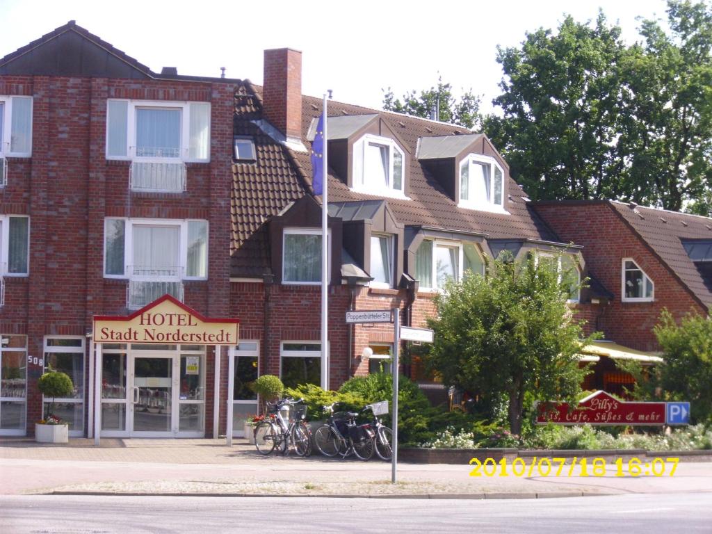 eine Gruppe von Fahrrädern, die vor einem Backsteingebäude geparkt sind in der Unterkunft Hotel Stadt Norderstedt in Norderstedt