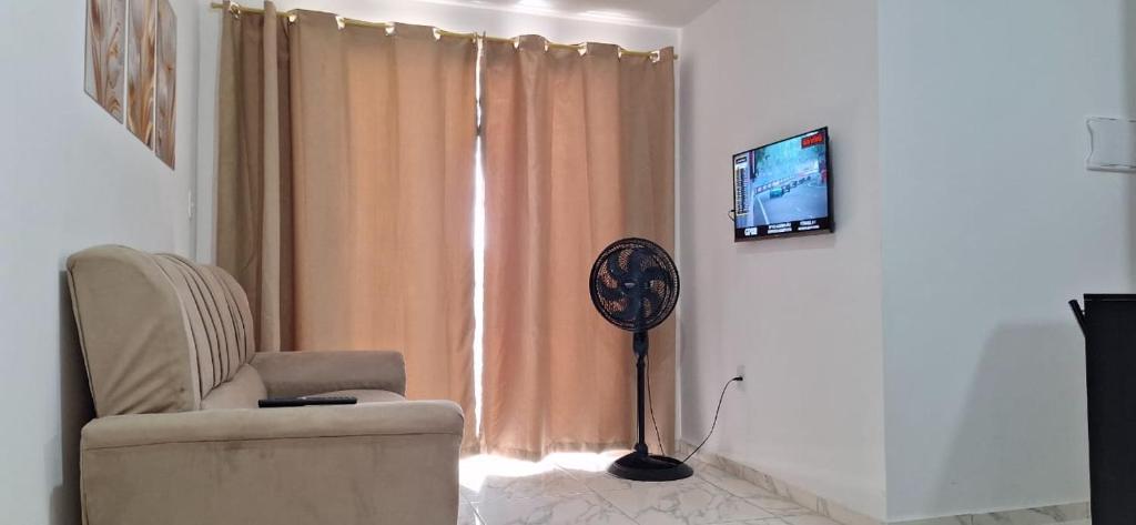 ジョアンペソアにあるNew apartment in João Pessoaの椅子と扇風機とテレビのあるリビングルーム