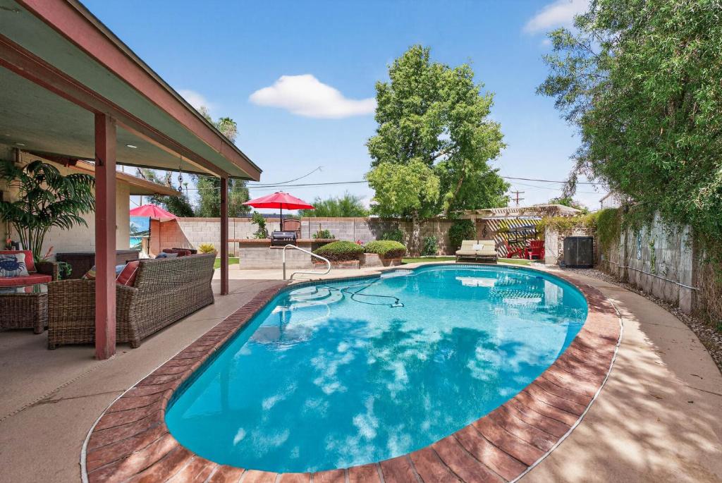 a swimming pool on a deck with a house at Pineapple Oasis - Heated Pool, ASU, Sleeps 12 in Tempe