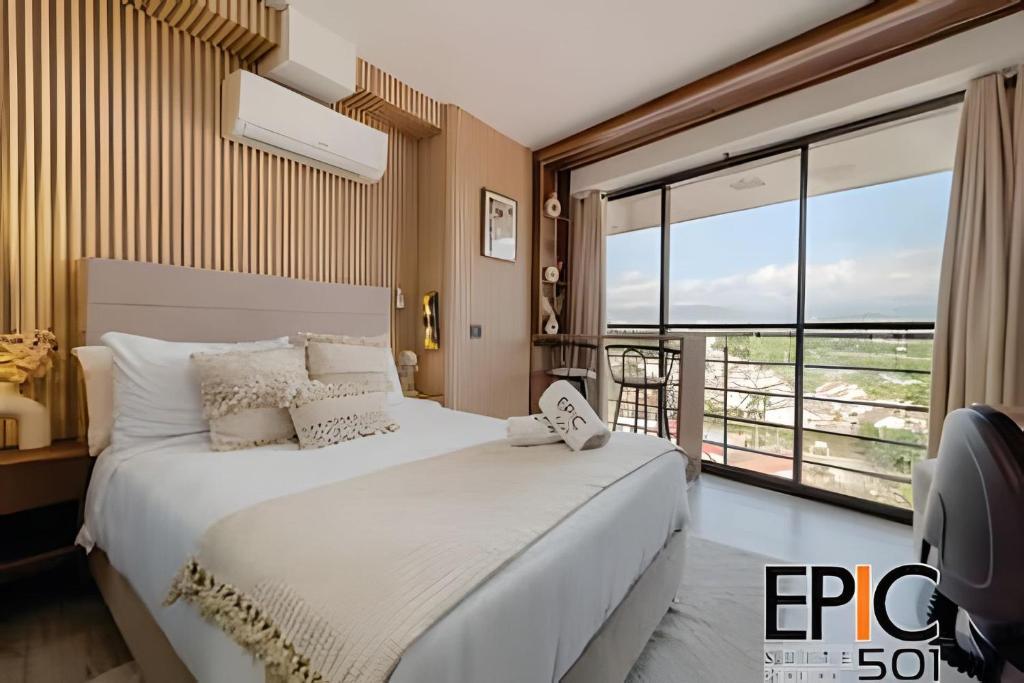 a bedroom with a large bed and a large window at Epic Suite 501 Deluxe Aeropuerto in Cuba