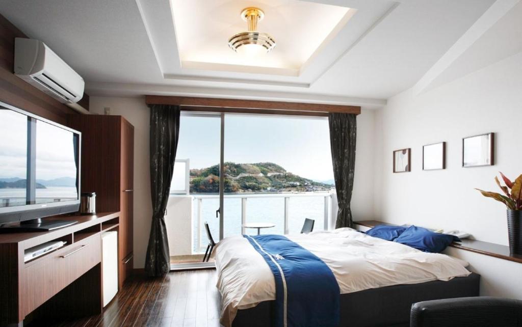 a bedroom with a bed and a large window at Hotel Mare - Vacation STAY 96730v in Kure