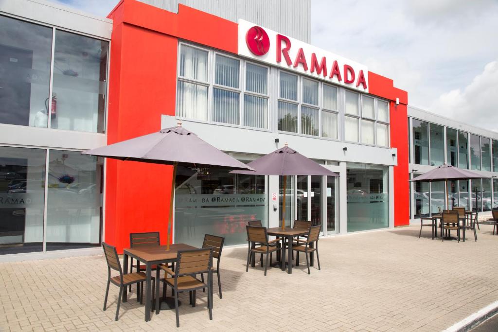 a group of tables and chairs in front of a building at Ramada Milton Keynes in Milton Keynes