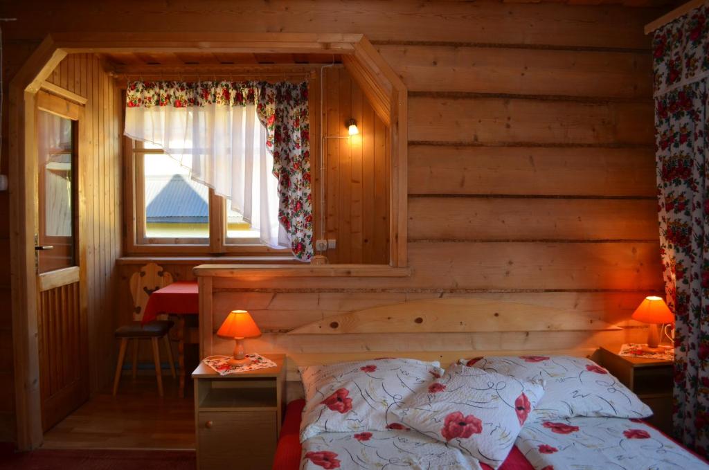 Un dormitorio con una cama en una cabaña de troncos en Chowańcówka, en Poronin