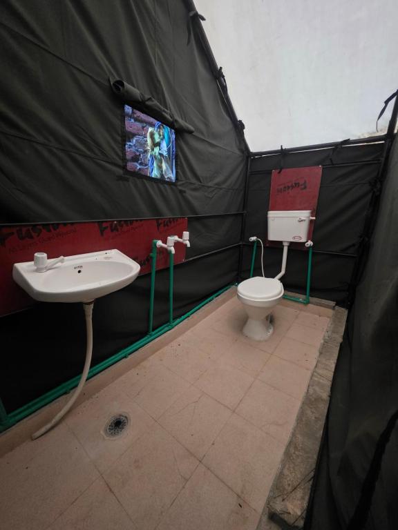 a bathroom with a sink and a toilet in a tent at Jalpa Camp Kasol in Kulu