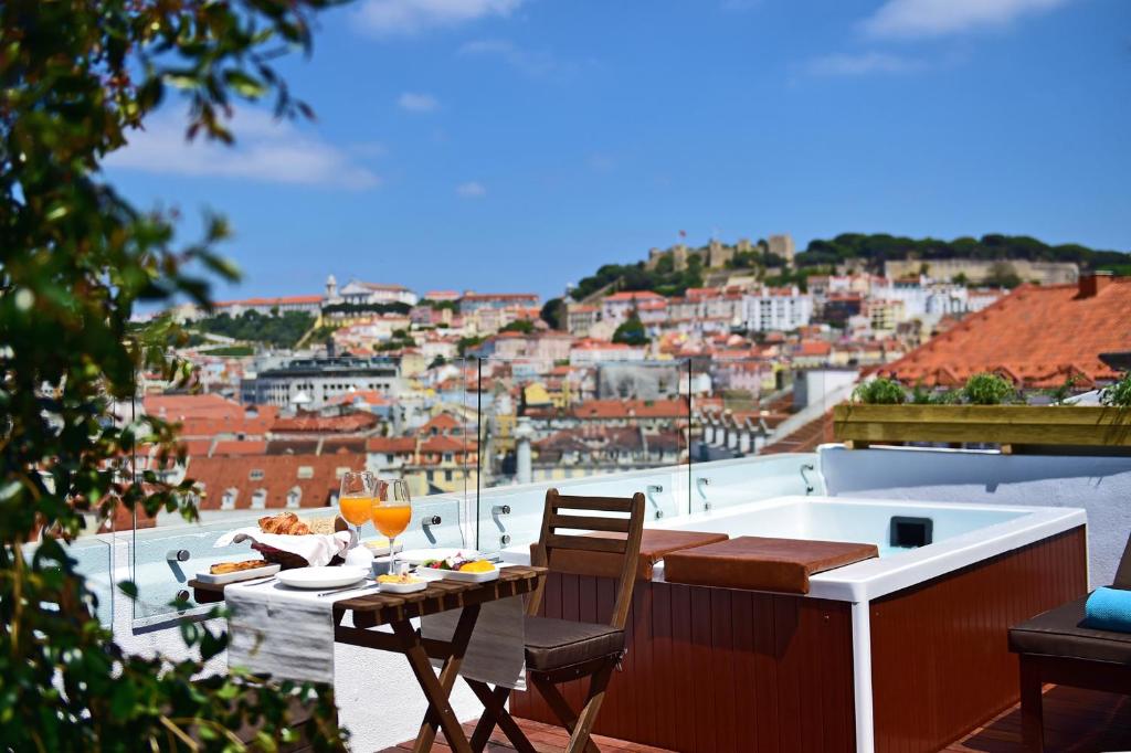 un tavolo e sedie su un balcone con vista sulla città di Casa Balthazar a Lisbona