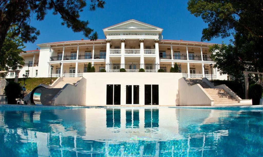 ein Gebäude mit einem Pool mit Wasser davor in der Unterkunft Hotel Imperial & Champagne SPA in Abrau-Djurso