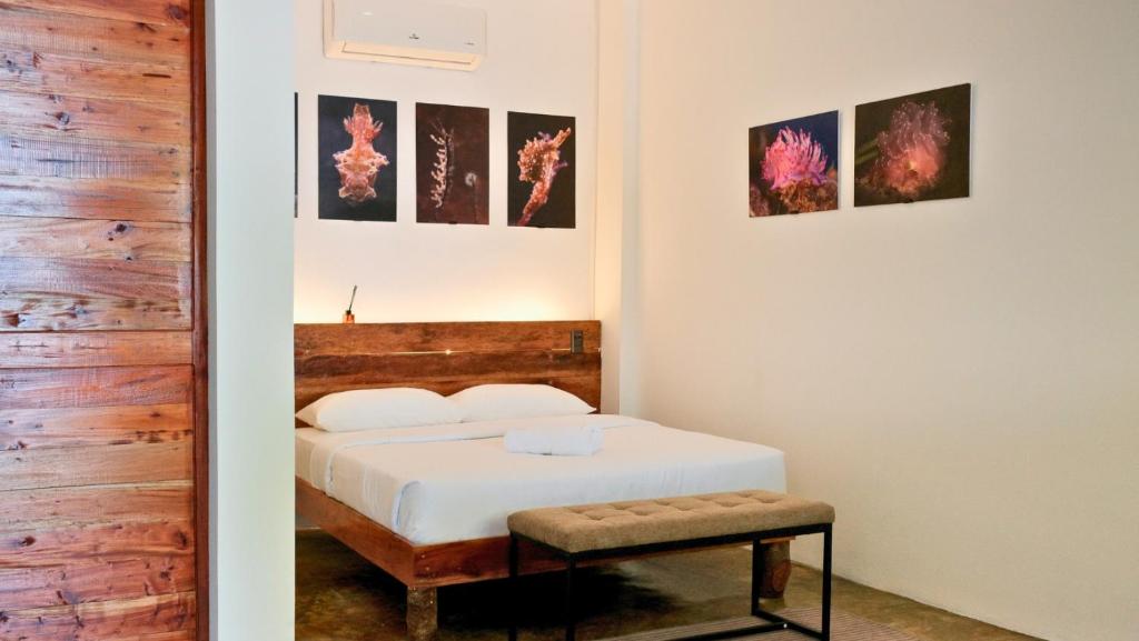 una camera da letto con un letto e alcuni quadri alle pareti di Critter Republic Dive Resort a Dauin