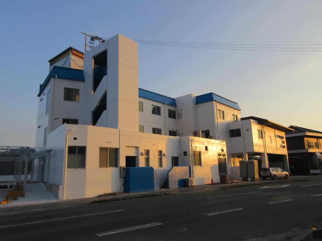 a white building on the side of a street at 森口屋アートスクエア in Shodoshima