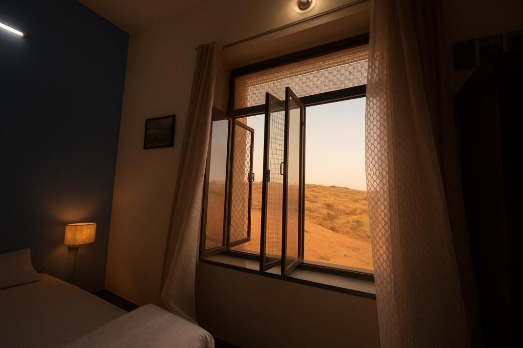 a bedroom with a window with a desert view at Pushkar Story Homestay in Pushkar