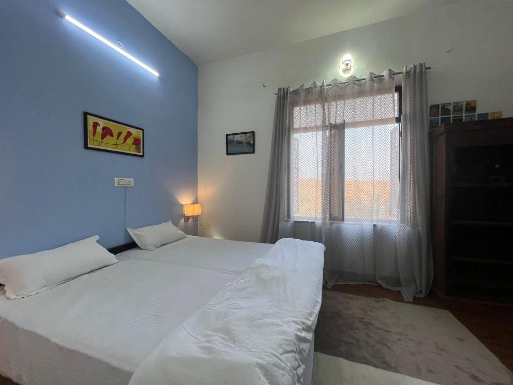 Un dormitorio con dos camas y una ventana. en Pushkar Story Homestay, en Pushkar