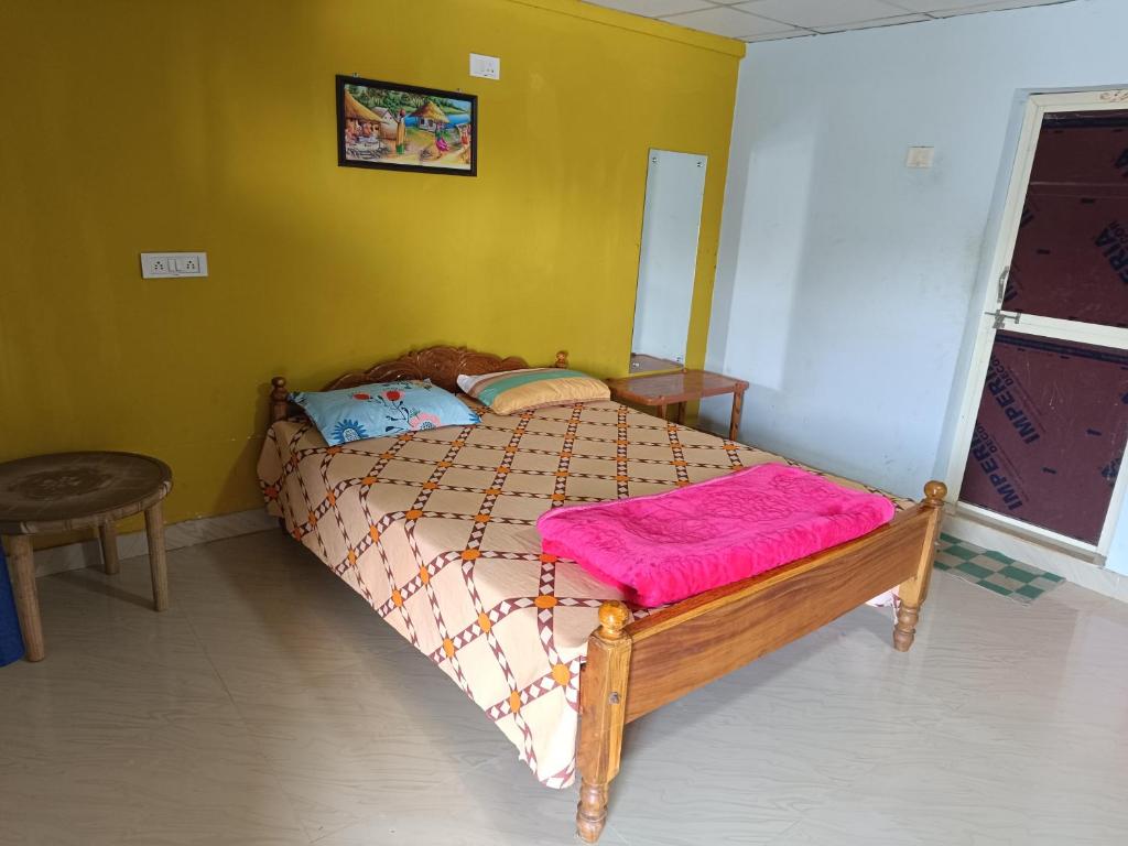 DāringbārhiRam Prakash Resorts的卧室配有一张黄色墙壁上的床