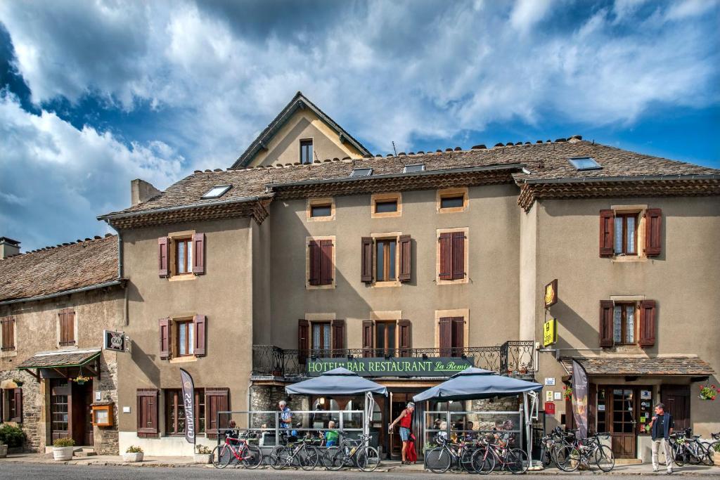 - un grand bâtiment avec des vélos garés devant dans l'établissement Logis Hôtel restaurant La Remise, à Le Bleymard