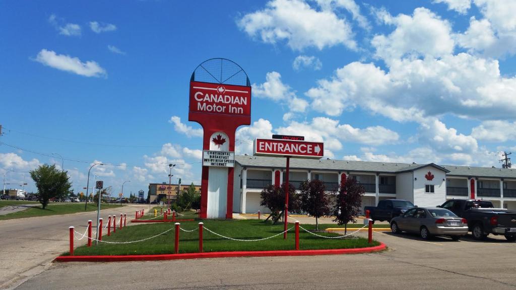 un edificio con un cartel para una posada de inventario de carillion en Canadian Motor Inn, en Grande Prairie
