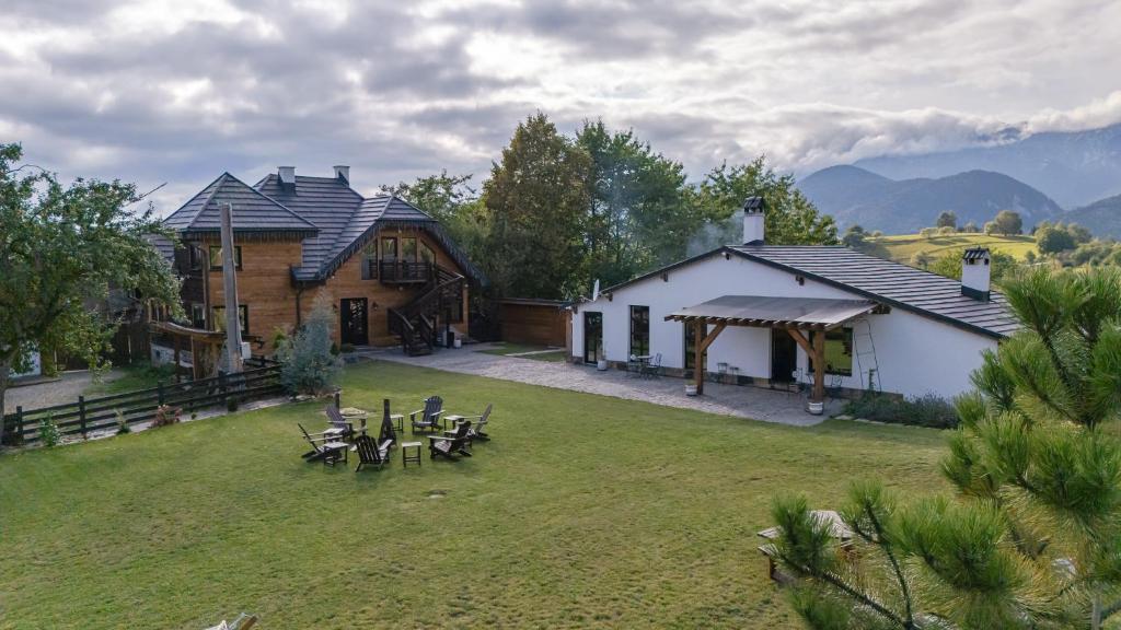 a house with a yard with tables and chairs at Westwand Villas in Măgura