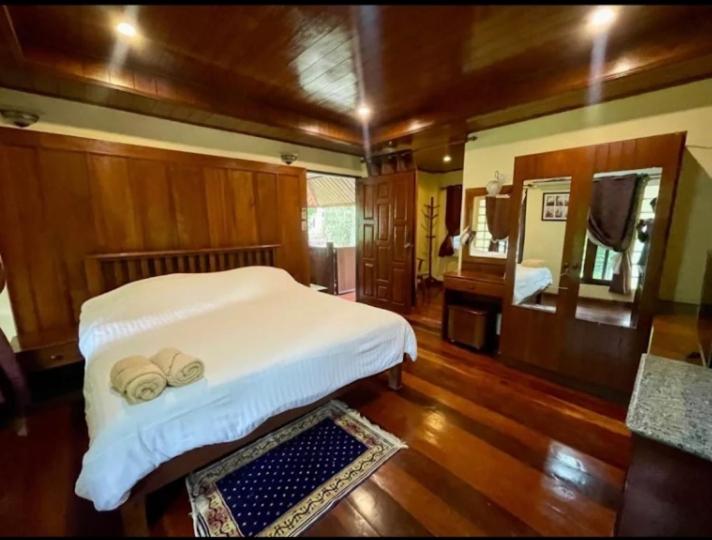 een slaapkamer met een bed met twee hoeden en een spiegel bij Harmony Home in Hang Dong