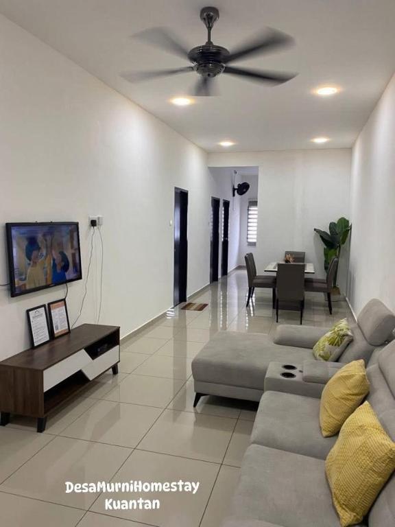 a living room with a couch and a ceiling fan at Desa Murni Homestay in Kuantan