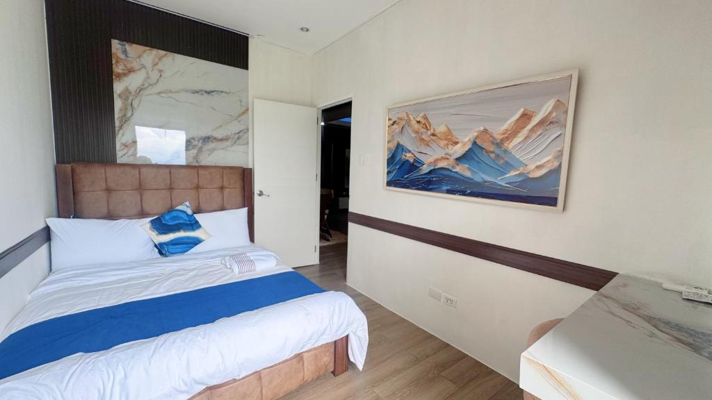 a bedroom with a bed and a painting on the wall at CoZerenity Stays - Premium two-bedroom Condo in Concepcion