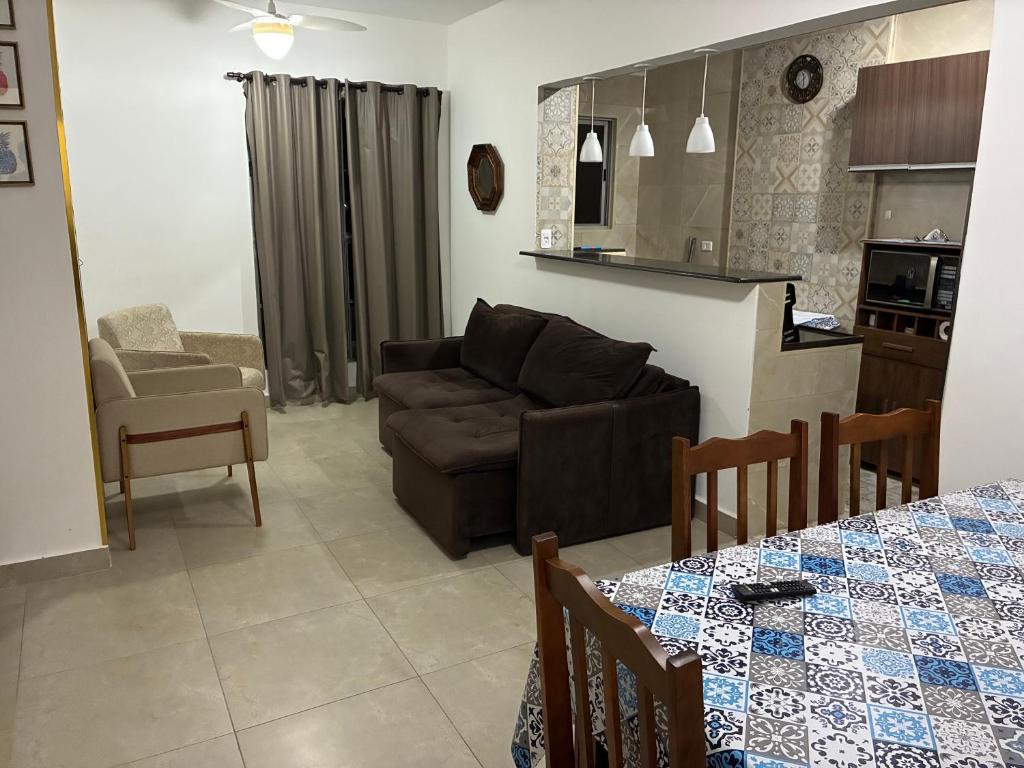 a living room with a couch and a table at Condomínio Itaparica III in Guarujá