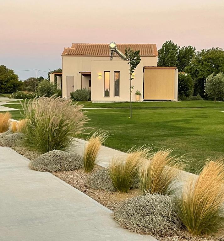 a house with a green yard with grass at Pnoe Eco Residences in Kourouta