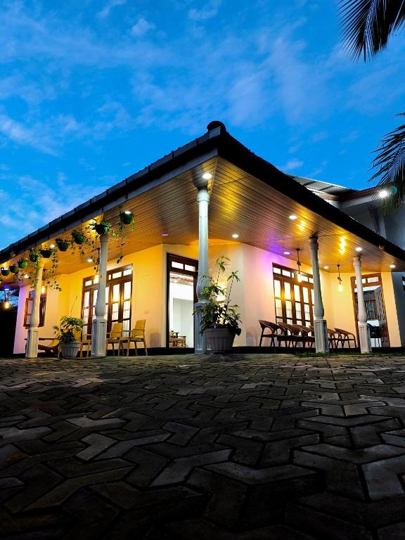 a building with tables and chairs at night at Freedom-Inn Resort Villa in Tangalle