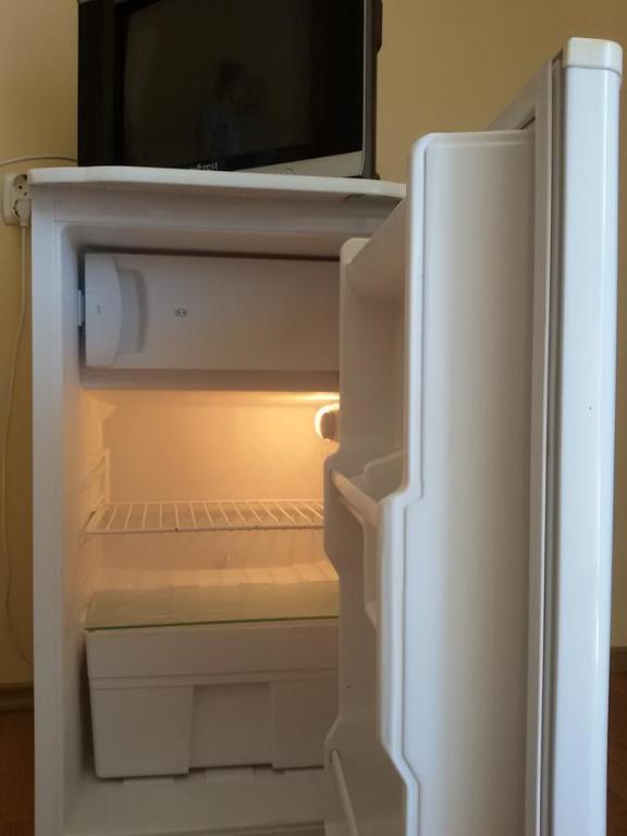 a refrigerator with its door open and a microwave at Vila Happy -only adults in Costinesti
