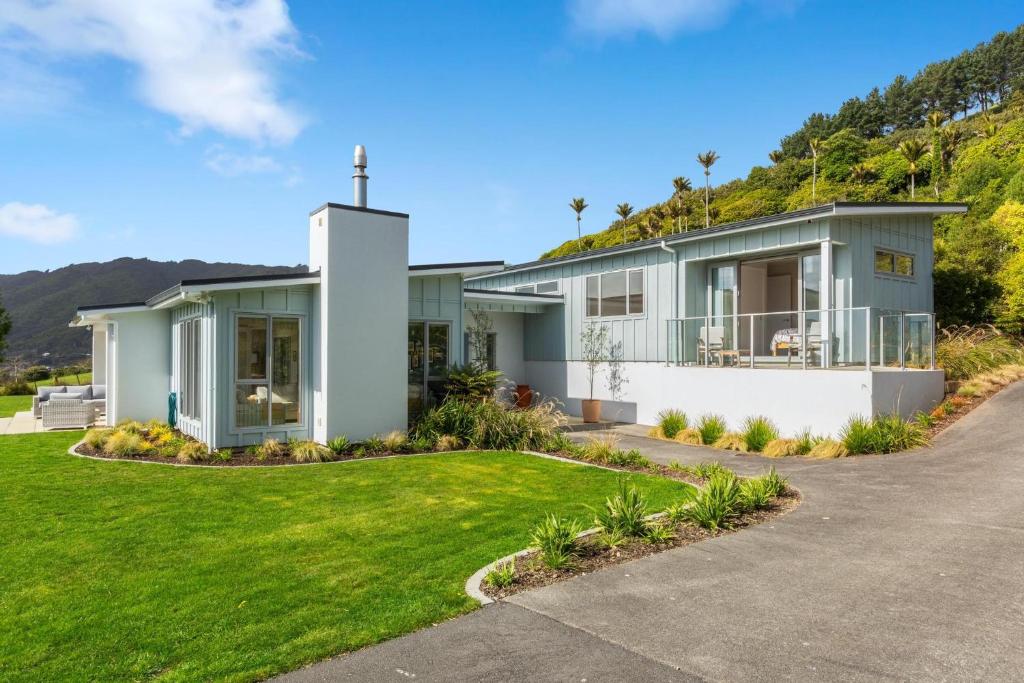 a house with a green lawn in front of it at Aston Road Villa Bed & Breakfast in Waikanae