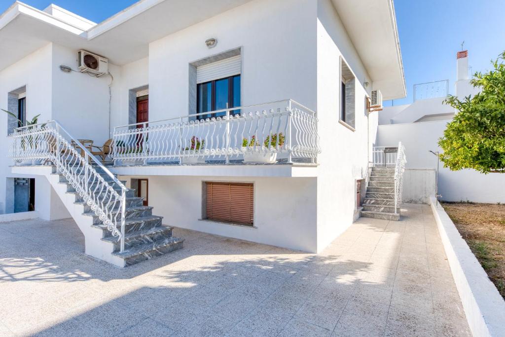 a white house with stairs and a balcony at Villetta Municipio - Salento in Castrignano del Capo