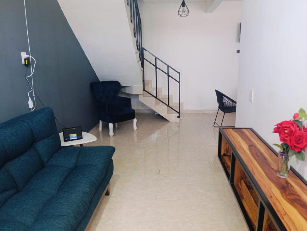 a living room with a blue couch and a staircase at Casa Jardín Los Potreros in San Juan Teotihuacán