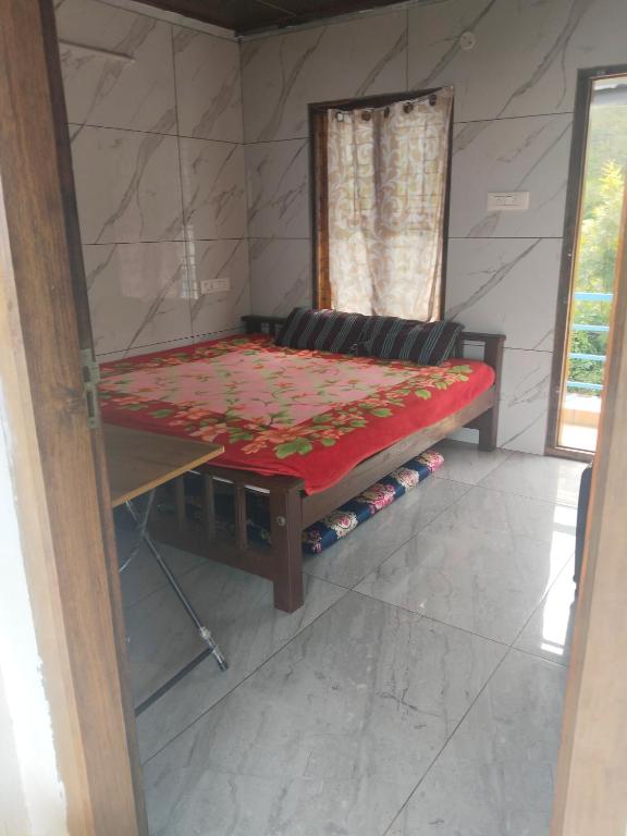 a small room with a bed and a table at Nachiyar Hotel in Kanthalloor