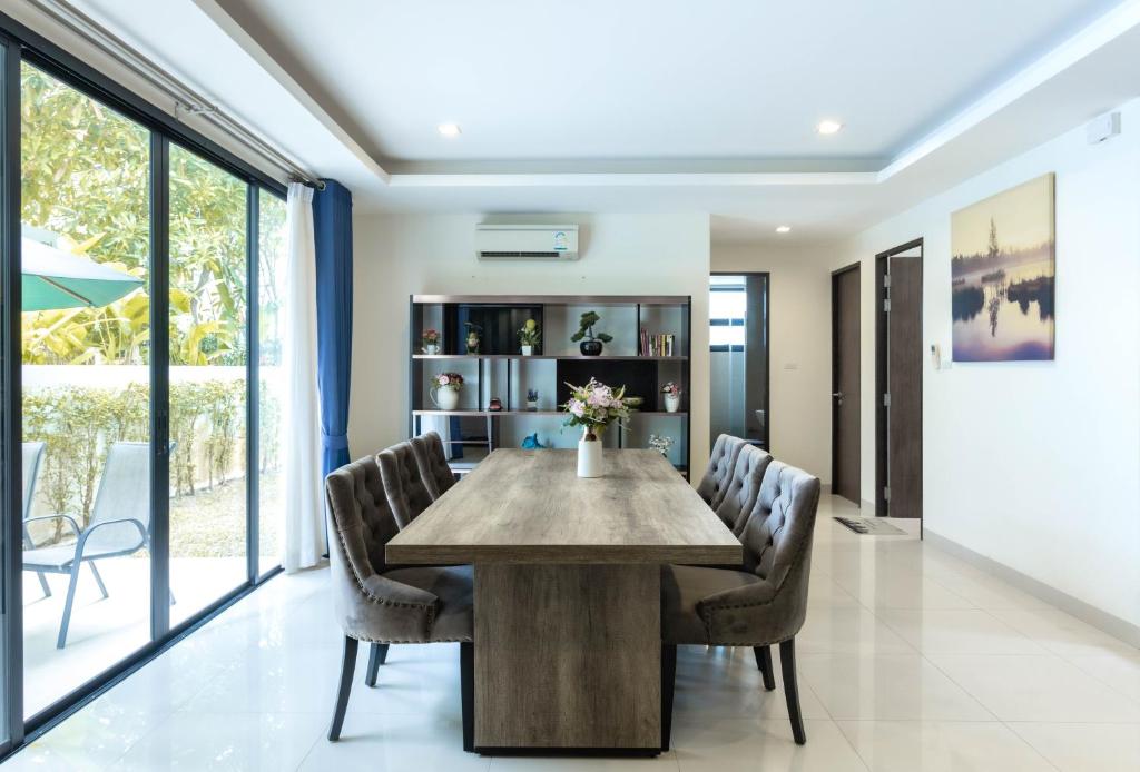 a dining room with a wooden table and chairs at Laguna Park Phuket in Bang Tao Beach