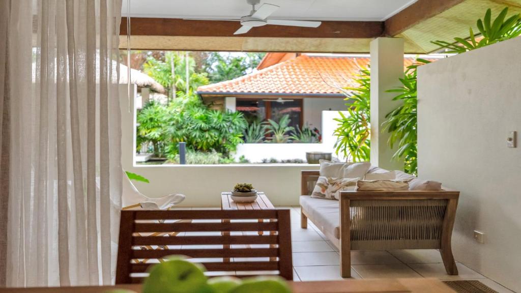 Una sala de estar con un sofá y una ventana grande. en Surya 7 Port Douglas, en Craiglie