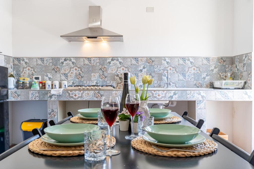 a table with two plates and glasses of wine at Villa Linda con Terrazzo in Giardini Naxos