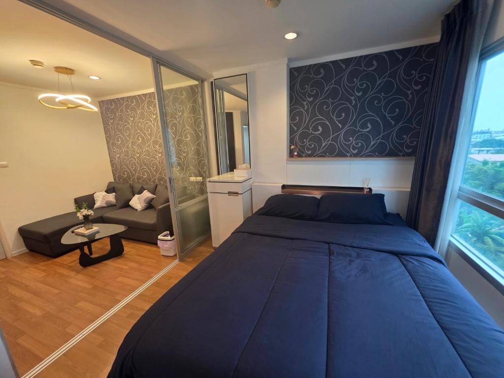 - une chambre avec un grand lit bleu et un canapé dans l'établissement City Center, Cozy room with Pool, Washing Machine, à Udon Thani