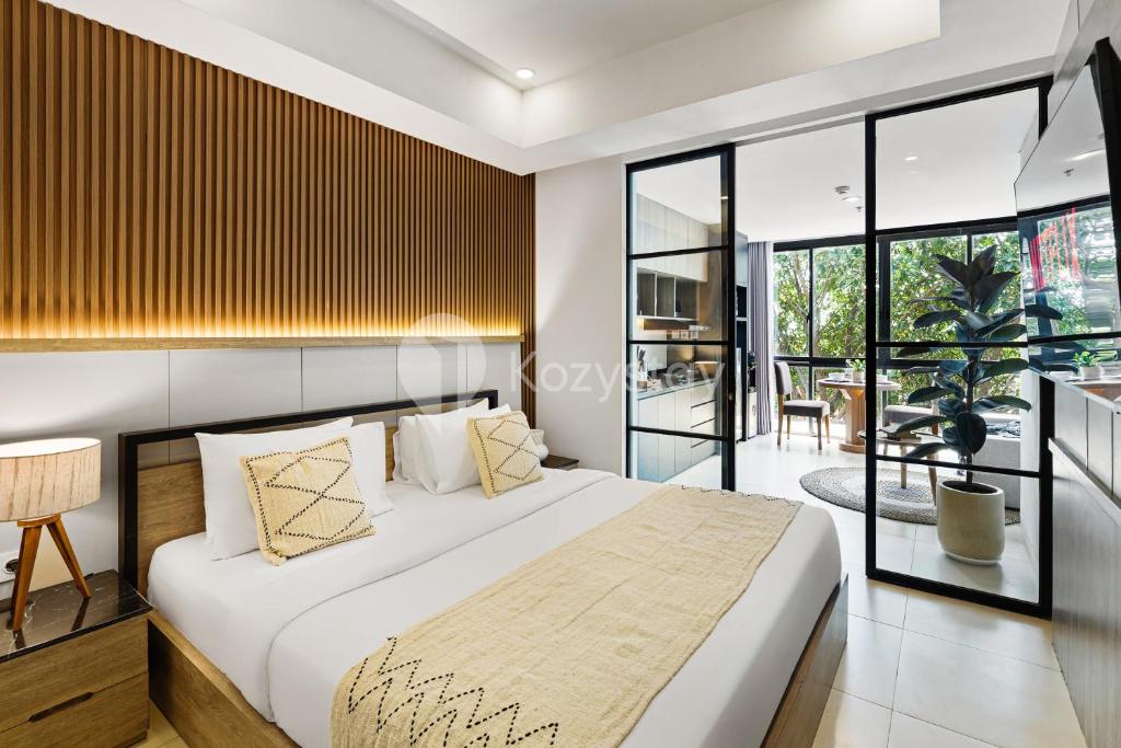 a bedroom with a large bed and a balcony at Caraya by Kozystay - Nusa Dua in Nusa Dua