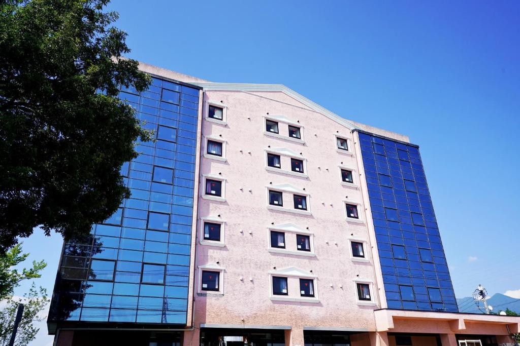 a building with glass windows on the side of it at ホテル韮崎インター in Nirasaki