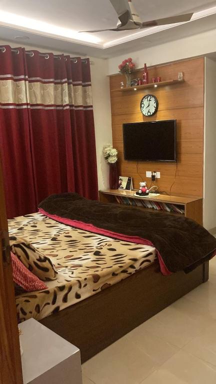 a bedroom with a bed and a clock on a wall at Modern Spacious and Calm Homestay in Panchkula