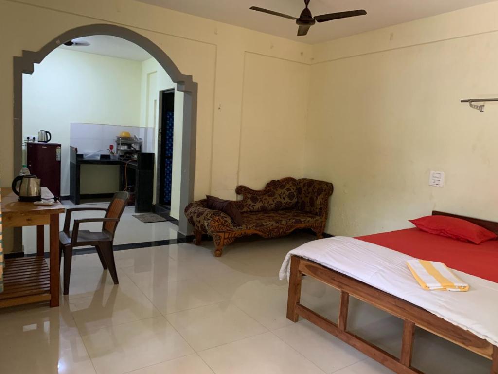 a bedroom with a bed and a living room at Prakash holliday home in Arambol