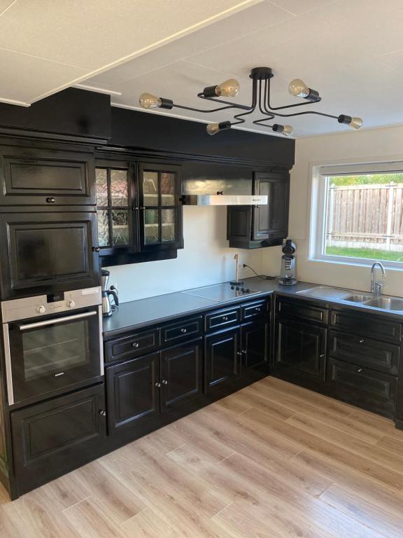 a kitchen with black cabinets and a ceiling at Vakantiewoning Oase in Groede