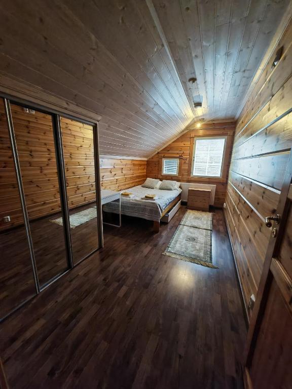 a room with a bed in a wooden cabin at Homely Loft in Punkaharju