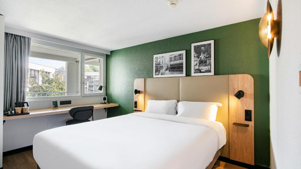 a bedroom with a white bed and a green wall at Campanile Prime - Aix-en-Provence Sud - Pont de l'Arc in Aix-en-Provence