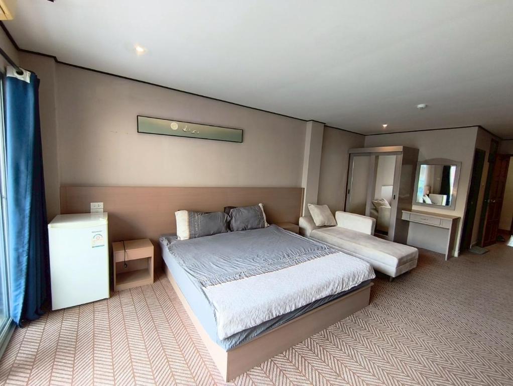 Un dormitorio con una cama grande y un espejo. en Peter's house2 Five minutes to the beach, en Pattaya South