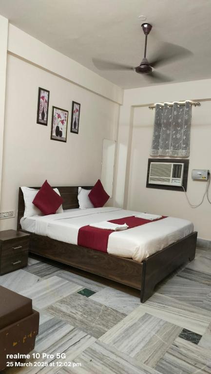 a bedroom with a large bed with red pillows at New Shanti Hotel in Prayagraj