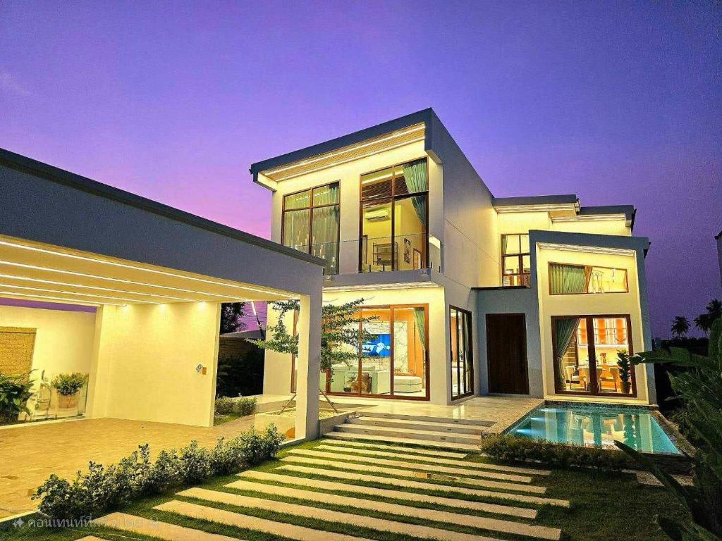 a large white house with a swimming pool at Home atmos prime villa pattaya in Ban Hui Yai Muk