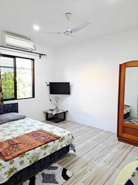 Un dormitorio con una cama y un televisor de pantalla plana. en Nav's B&B, en Nadi