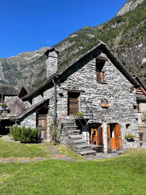 a stone house with a mountain in the background at Casa Meridiana - Sonlerto - Val Bavona in Cevio