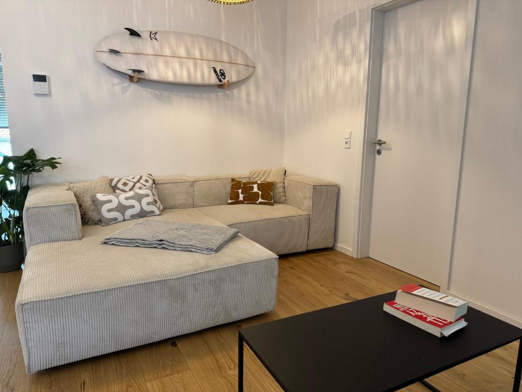 a living room with a couch and a surfboard on the wall at Zentrale Citywohnung Bayreuth, Loggia, Garage in Bayreuth