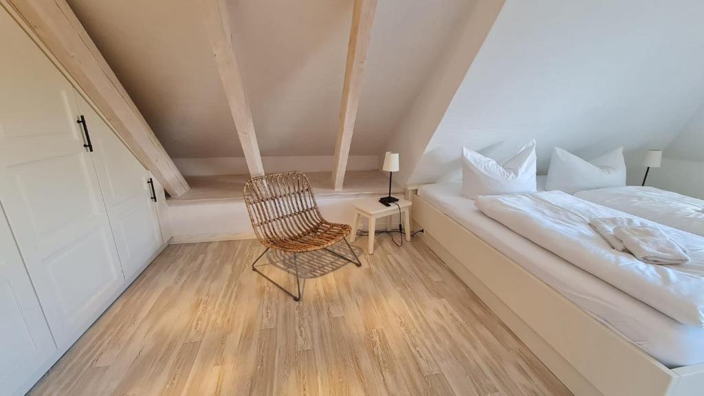 a small bedroom with a bed and a chair at Insel Landhaus Feuerstein in Gager